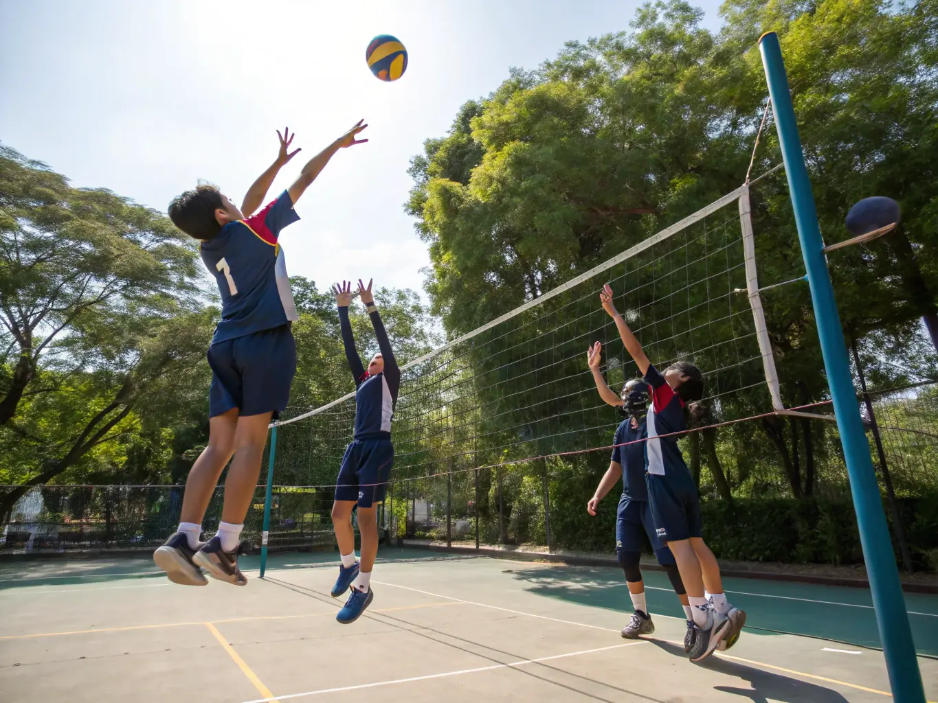 A cheerful image of students playing volleyball outdoors, emphasizing coordination and fun.